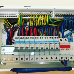 Close-up view of a neatly organised electrical consumer unit with labelled circuit breakers and colour-coded wiring. This image demonstrates expert electrical workmanship with a focus on safety and efficiency, suitable for residential or commercial electrical systems."