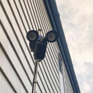 Motion-activated floodlight security system installed on a modern building in Helston, Cornwall, by AMP Electrical Solutions.