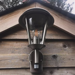 Outdoor light with motion sensor installed on a wooden building in Helston, Cornwall, by AMP Electrical Solutions.